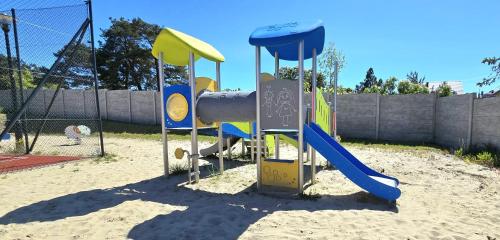 a playground with a slide in the sand at Apartament Perła Jantaru by TriApart in Jantar