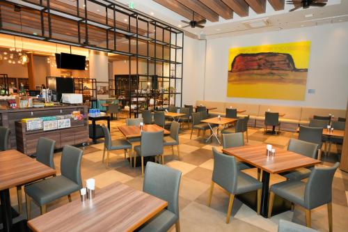 a restaurant with tables and chairs and a bar at Airport Hotel Kumamoto in Ozu