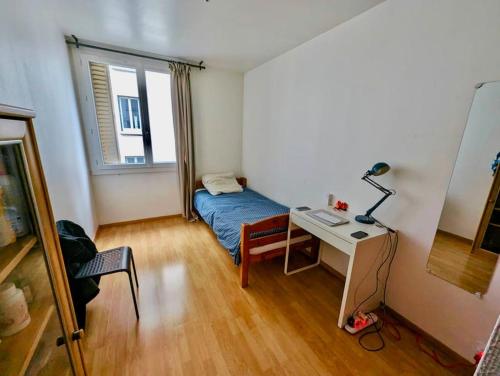Cette petite chambre comprend un lit et un bureau avec une lampe. dans l'établissement Chambre au Cœur Grenoble - Calme & Tout Equipé avec WIFI, à Grenoble