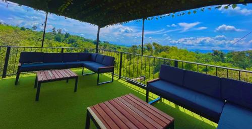 two blue benches on a balcony with a view at Hotel Campestre Atardecer Cafetero in Quimbaya