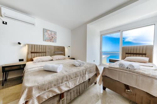 2 łóżka w sypialni z widokiem na ocean w obiekcie Resort Stikovic w Dobrej Vodzie