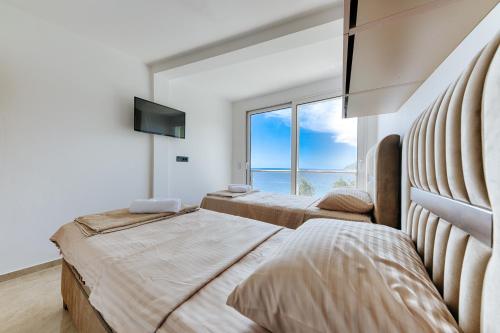 two beds in a bedroom with a large window at Resort Stikovic in Dobra Voda