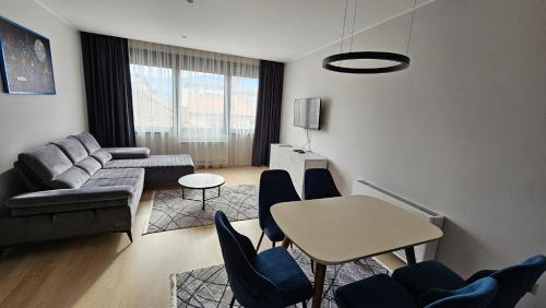a living room with a couch and a table and chairs at Moaline Apartments, free parking in Sarajevo