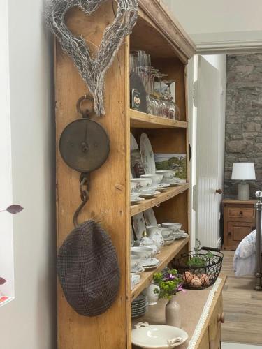 a wooden cabinet filled with plates and dishes at The Old House at Belfield in Tralee