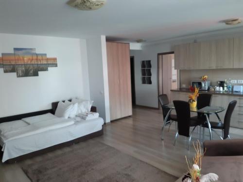 a living room with a white couch and a table at Apartament Marcel - Coresi Mall in Braşov