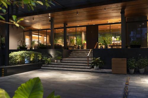 a lobby of a building with stairs and potted plants at Ad Lib Hotel Bangkok in Bangkok