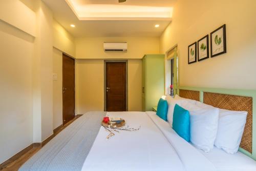a bedroom with a white bed with a table on it at ELIVAAS 3 BHK with Pvt Pool - Azalea in Siolim