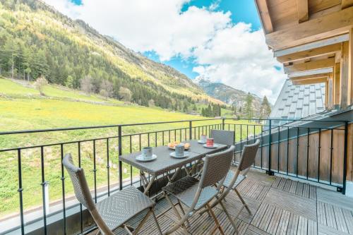 a patio with a table and chairs on a balcony at Vallorcine Apartments - Happy Rentals in Vallorcine