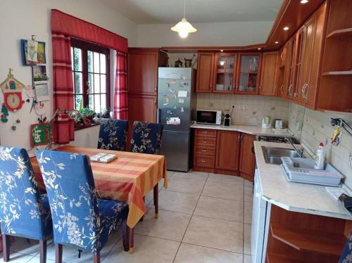 a kitchen with a table and chairs and a refrigerator at Pine Grove Villa in Gödöllő