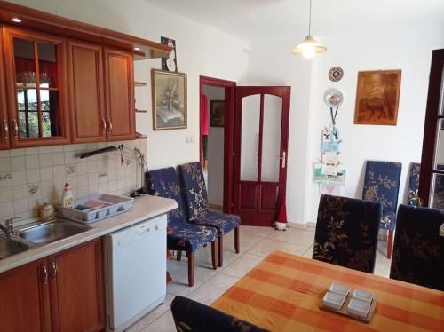 a kitchen with a sink and a table and chairs at Pine Grove Villa in Gödöllő