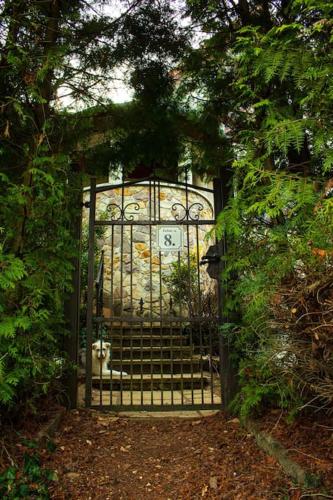 a gate with a clock on it in a garden at Pine Grove Villa in Gödöllő