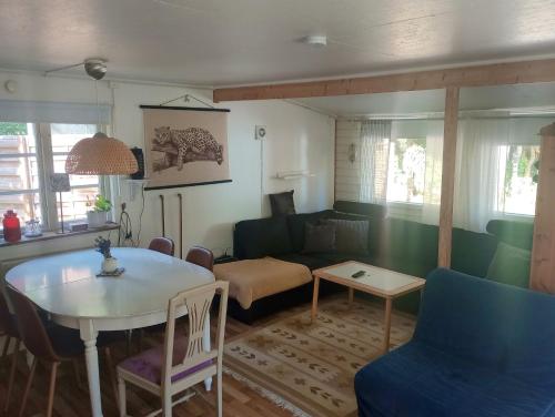 - un salon avec une table et un canapé dans l'établissement Ackes Stuga 32, à Örebro