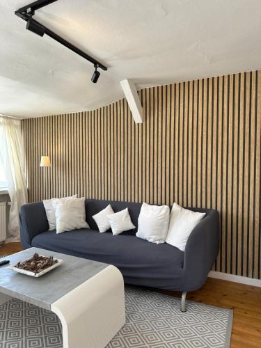 ein Wohnzimmer mit einem blauen Sofa und weißen Kissen in der Unterkunft Schönes City-Apartment mit 2 Schlafzimmer, Parkplatz, ruhig und hell, D46-DG in Oldenburg