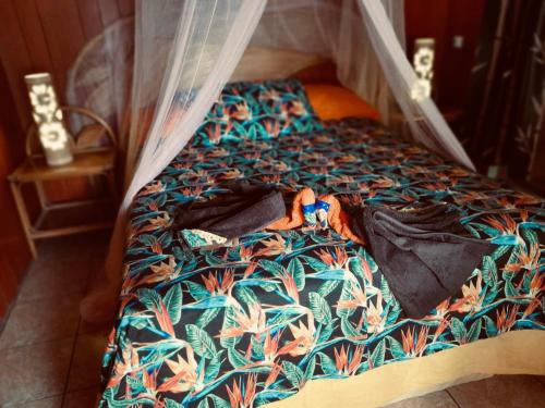 a bed with a comforter on top of it at Monita villa Tiputa in Tiputa