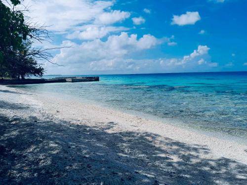 a beach with blue water and a blue sky and clouds at Monita villa Tiputa in Tiputa