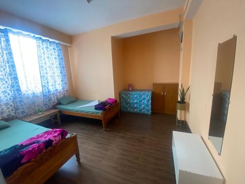 Zimmer mit 2 Betten und einem Fenster in der Unterkunft Ritesh BNB in Gangtok