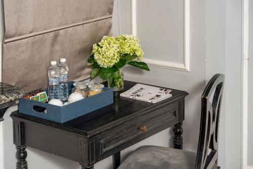 a table with a vase of flowers and water bottles on it at Amara Hanoi Hotel in Hanoi