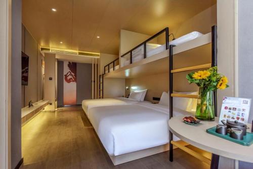 a bedroom with a large white bed and bunk beds at Heye Youth Hostel - Xian Bell Tower in Xi'an