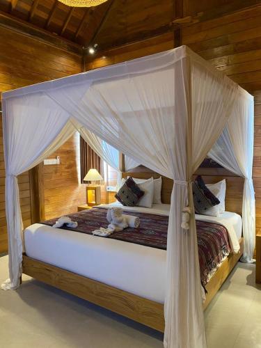 a bedroom with a canopy bed with stuffed animals on it at Kubu Sakian Villa and Restaurant Sidemen in Silebeng