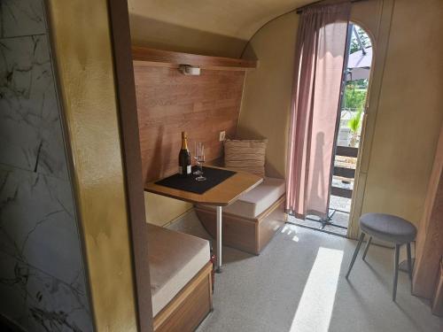 een kleine kamer met een tafel en een fles wijn bij River Houses Ljubljanica in Ljubljana