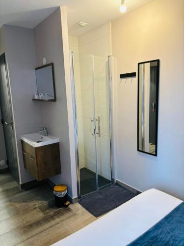 une salle de bain avec une douche en verre et un lavabo dans l'établissement Au Relais Gascon, à Labastide-dʼArmagnac