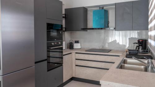 a kitchen with black and white cabinets and a sink at Adaman Villas in Meganisi