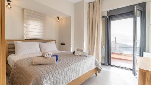 a bedroom with a large bed with towels on it at Adaman Villas in Meganisi