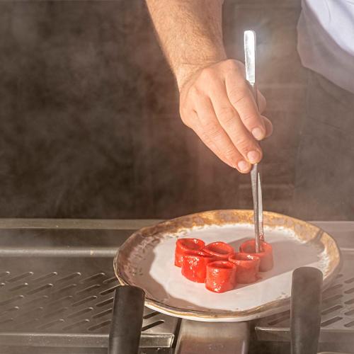 a person holding a knife and a plate of tomatoes at Il Castagneto Hotel in Melfi