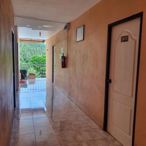 a hallway with a white door and a room with a view at 8 homestel in Koh Tao