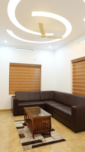 a living room with a couch and a coffee table at Neom's Golden Gate in Alwaye