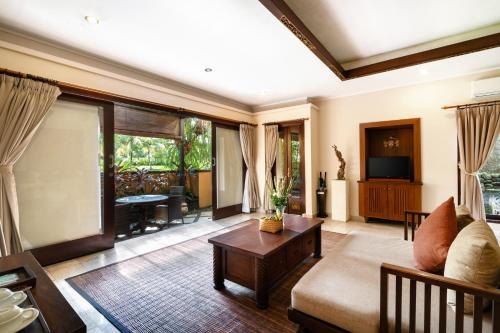 a living room with a couch and a table at Svarga Bebek Villas in Ubud