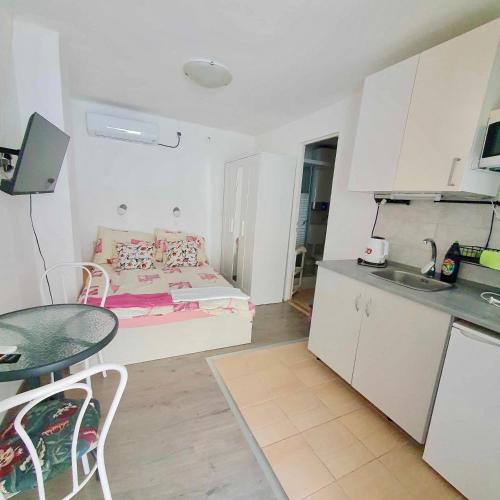 a kitchen and a living room with a table and a couch at ARANY13 Apartmanház - Mówimy po polsku! in Bogács