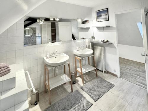 ein Badezimmer mit 2 Waschbecken und einem Spiegel in der Unterkunft Demeure de 6 chambres avec piscine interieure sauna et jardin clos a Vernou sur Brenne in Vernou-sur-Brenne