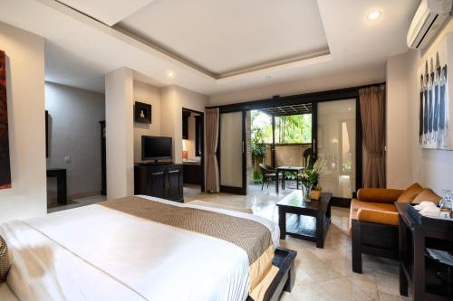a bedroom with a bed and a living room at Svarga Bebek Villas in Ubud