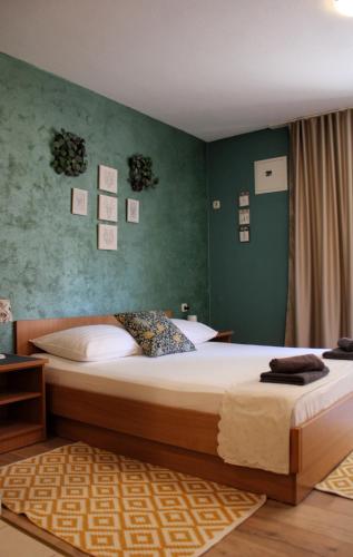 a bedroom with two beds and a green wall at Studio apartment Laura-spacious studio on the main beach in Makarska