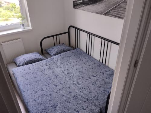 uma pequena cama num quarto com uma janela em LUX Apartament em Chrzanów