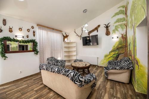 a living room with zebra chairs and a tv at Chalupa Dešná in Dešná
