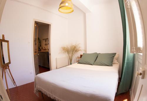 - une chambre avec un lit blanc et un cadre vert dans l'établissement Charmant 2 pièces Halles de Toulon, à Toulon
