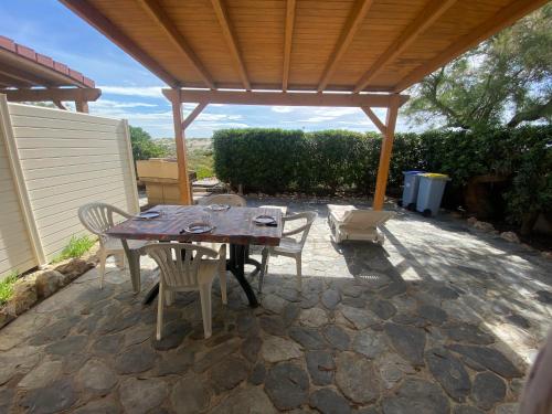 - un patio avec une table et des chaises en bois sous un pavillon dans l'établissement Appart rdc accès direct plage 6ARIST8, au Barcarès