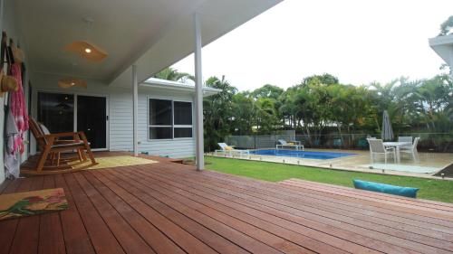 une grande terrasse en bois avec un patio et une piscine dans l'établissement Le Belle Aimante, Magnetic Island, à Horseshoe Bay