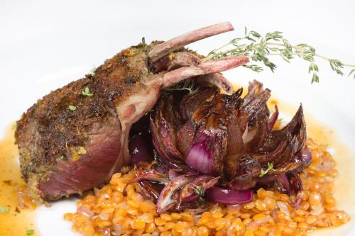 a plate of food with a piece of meat and corn at Hotel Bratislava in Bratislava