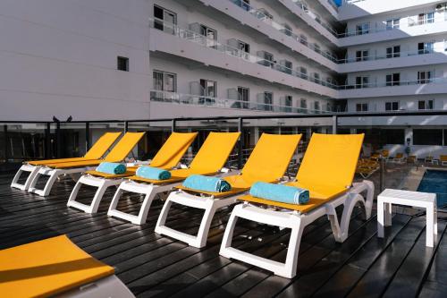 une rangée de chaises et de tables jaunes sur un navire de croisière dans l'établissement Port Fiesta Park, à Benidorm