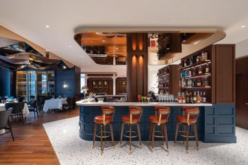 a bar in a restaurant with orange stools at A T HOUSE Shanghai City Center Xujiahui - Free Night Snacks from 930pm-11pm in Shanghai