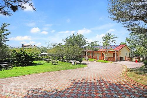 a brick driveway leading to a house with a garden at 清境 百里莊園 Baili Manor Cing Jing in Renai