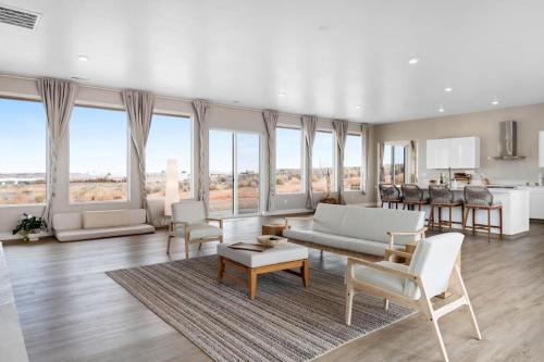 una gran sala de estar con muebles y ventanas blancos. en Tranquil Zen Retreat with Amazing Mesa Views, en Big Water