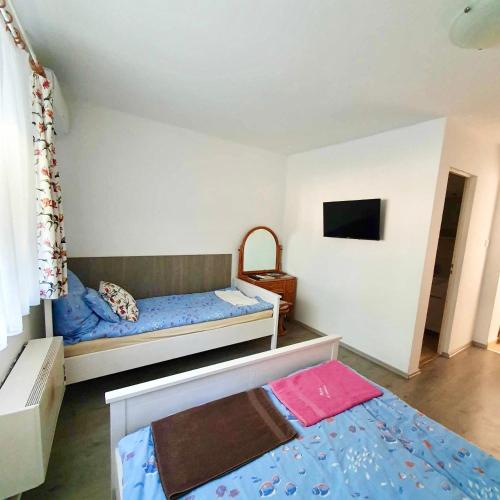 a bedroom with two bunk beds and a television at ARANY13 Apartmanház - Mówimy po polsku! in Bogács