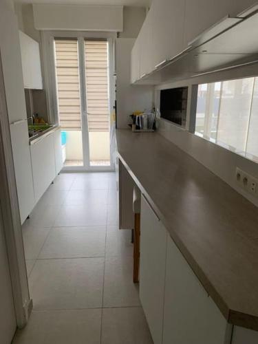 - une grande cuisine avec un long comptoir dans une pièce dans l'établissement Très bel appartement 2 pièces, à Nice