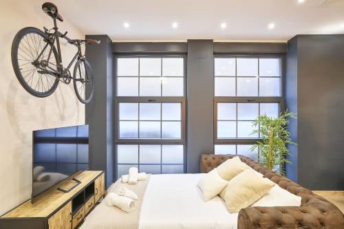 Una bicicleta colgada sobre una cama en un dormitorio en Loft diseño el taller del abuelo con parking en Salamanca