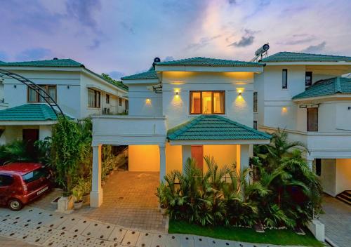 a house with a red car parked in front of it at ELIVAAS 3 BHK with Pvt Pool - Azalea in Siolim
