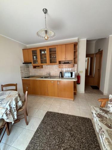 a kitchen with wooden cabinets and a table and a couch at Vila Weekend in Rogaška Slatina